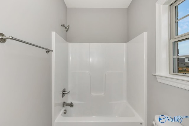 bathroom featuring shower / washtub combination and toilet