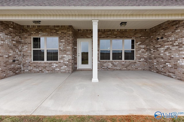 view of exterior entry with a patio area