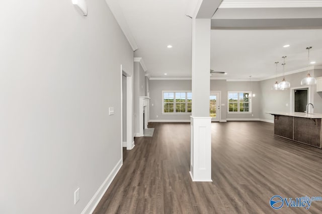 unfurnished living room with a sink, dark wood-style floors, and baseboards