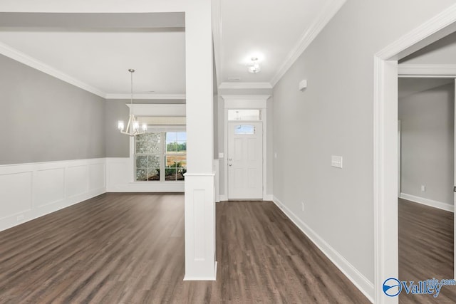 foyer featuring crown molding, dark wood-type flooring, and a chandelier