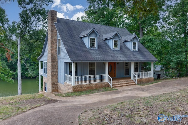 cape cod home featuring a porch