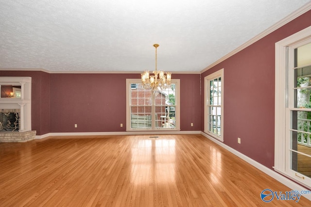 spare room featuring baseboards, a notable chandelier, light wood-style flooring, and ornamental molding