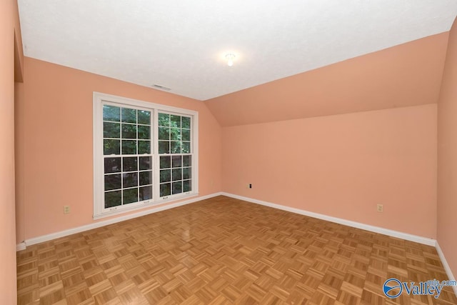 additional living space with visible vents, baseboards, and lofted ceiling