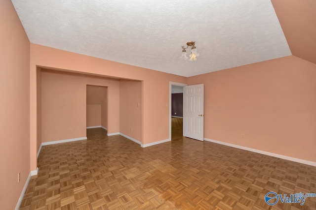 spare room with baseboards, a textured ceiling, and a chandelier
