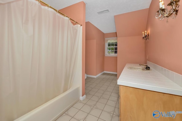 full bath with tile patterned floors, visible vents, a textured ceiling, baseboards, and vaulted ceiling