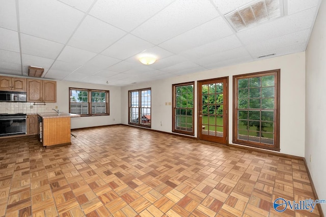 kitchen featuring visible vents, open floor plan, gas stove, a peninsula, and light countertops