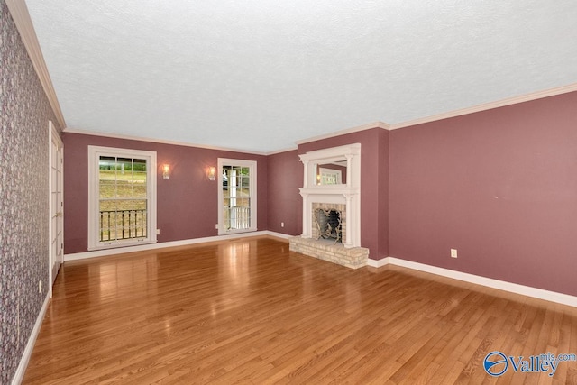 unfurnished living room featuring crown molding, wood finished floors, baseboards, and a textured ceiling