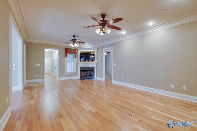 unfurnished living room featuring a ceiling fan, ornamental molding, light wood finished floors, and baseboards