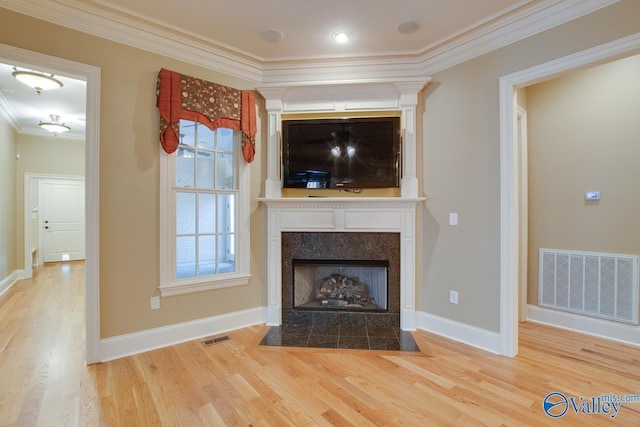 unfurnished living room with crown molding, visible vents, wood finished floors, and a fireplace with flush hearth