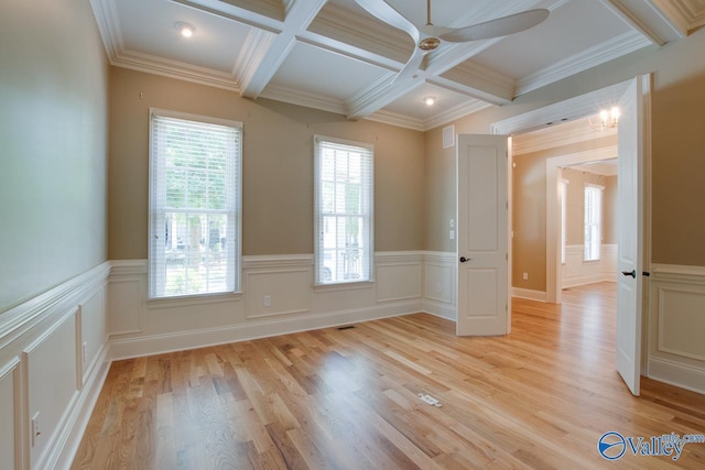 spare room with coffered ceiling, wainscoting, light wood-style floors, and beam ceiling