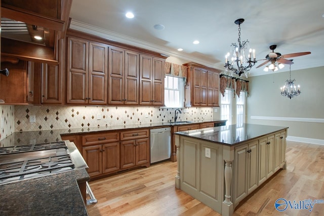 kitchen with a sink, ornamental molding, dishwasher, decorative backsplash, and hanging light fixtures
