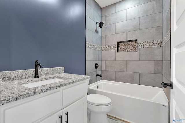 full bathroom with vanity, tiled shower / bath combo, and toilet