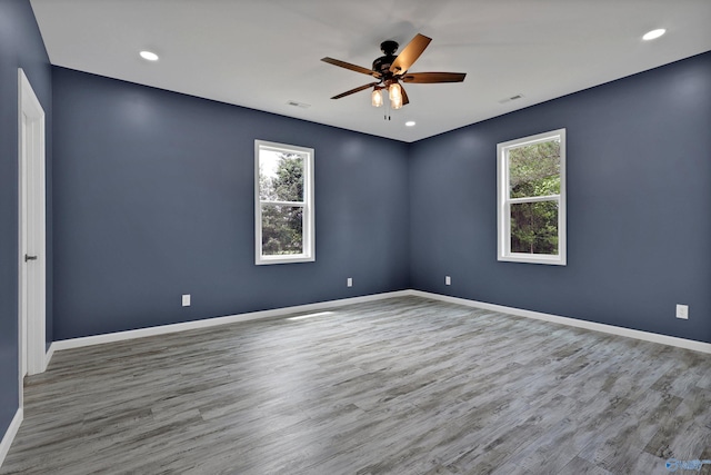 empty room with hardwood / wood-style floors and ceiling fan