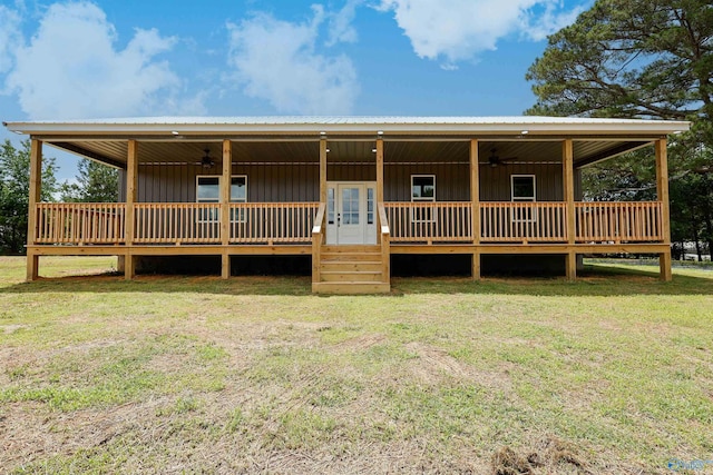 view of front of home featuring a deck, ceiling fan, and a front lawn