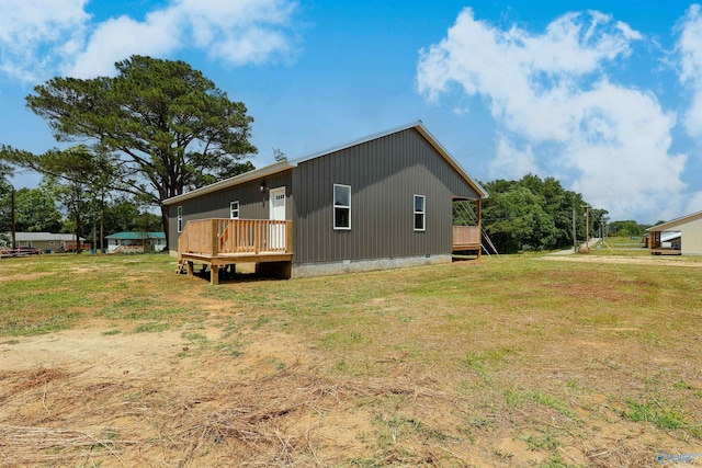 view of side of property featuring a wooden deck and a lawn