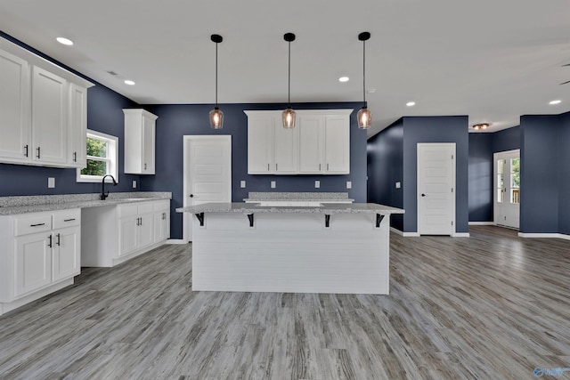 kitchen featuring a healthy amount of sunlight, white cabinets, and light wood-type flooring