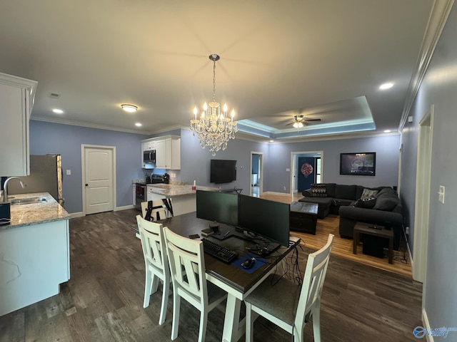 dining area with ceiling fan with notable chandelier, crown molding, dark wood-type flooring, and sink