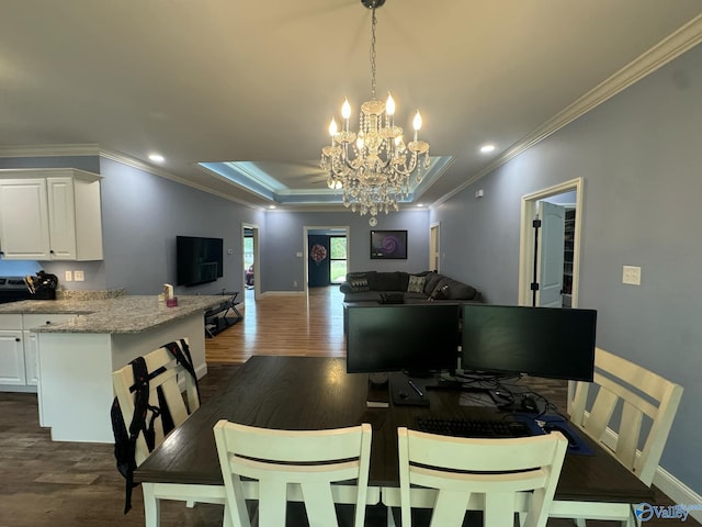 dining room featuring dark hardwood / wood-style flooring, ornamental molding, and a notable chandelier