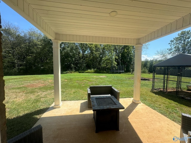 view of patio / terrace with a fire pit, a gazebo, and a trampoline