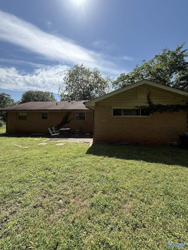 528 Delaney Rd, Huntsville, AL 35806 - view of home's exterior featuring a patio, a yard, and brick siding