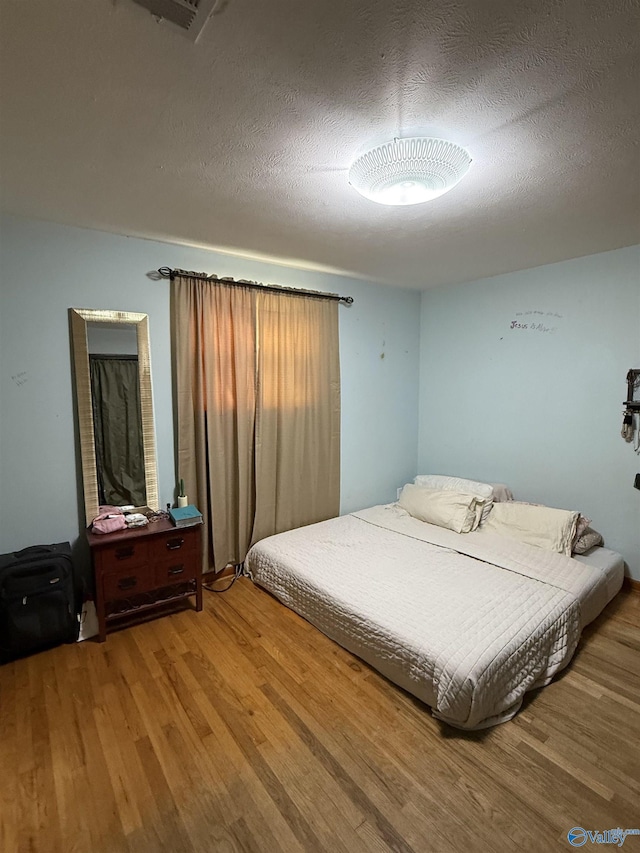528 Delaney Rd, Huntsville, AL 35806 - bedroom featuring wood finished floors and a textured ceiling