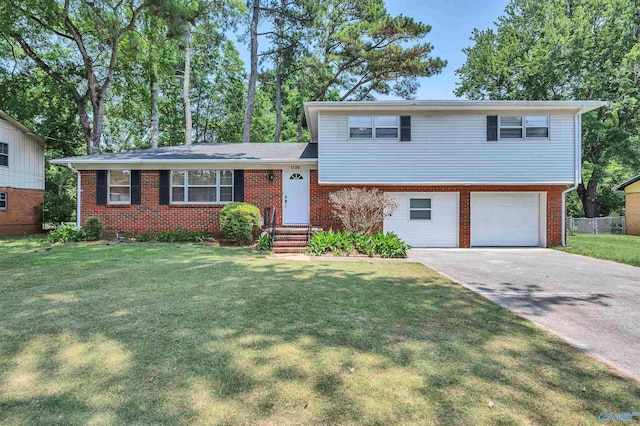 split level home featuring a front yard, brick siding, and driveway