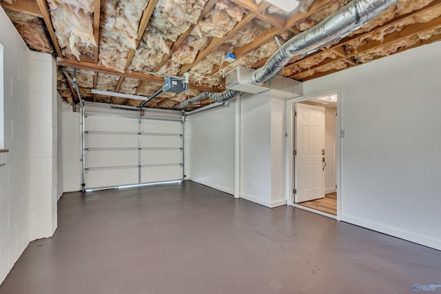 1126 Oster Dr, Huntsville, AL 35816 - garage featuring a garage door opener, concrete block wall, and baseboards