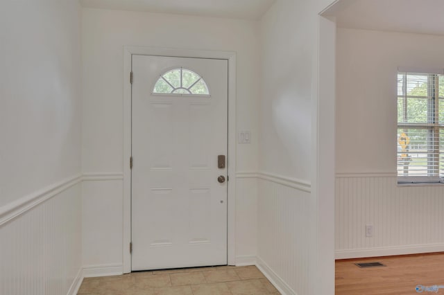 entryway with a wainscoted wall, light wood-style flooring, and visible vents