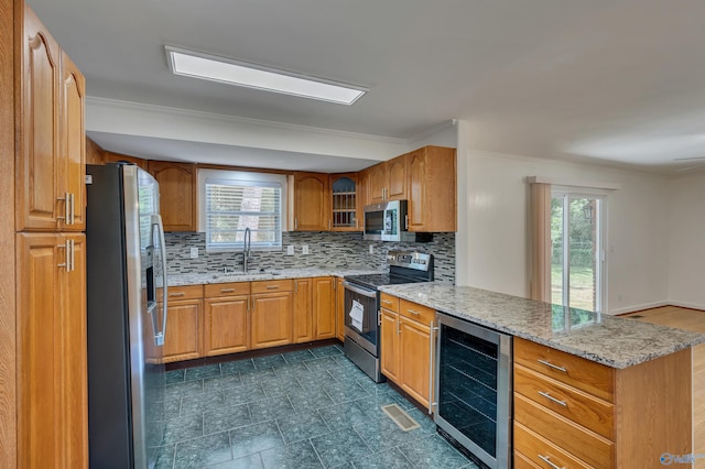 kitchen with appliances with stainless steel finishes, dark tile patterned floors, tasteful backsplash, sink, and wine cooler