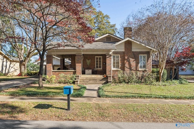 view of front of property with a porch and a front lawn