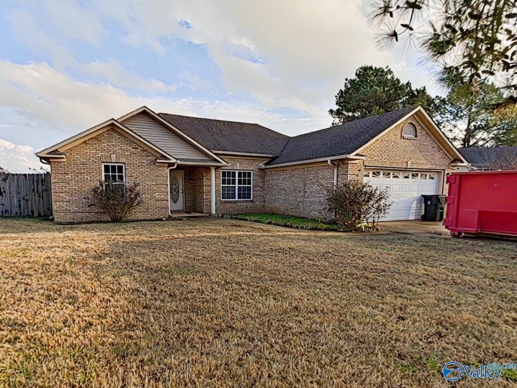 ranch-style house featuring a front yard and a garage