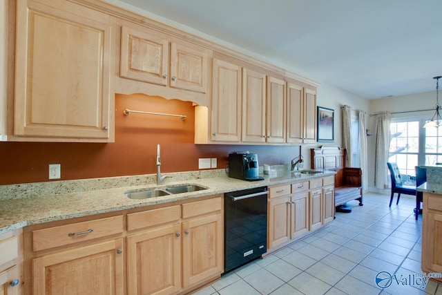 kitchen featuring a sink, black dishwasher, light tile patterned floors, and light brown cabinetry