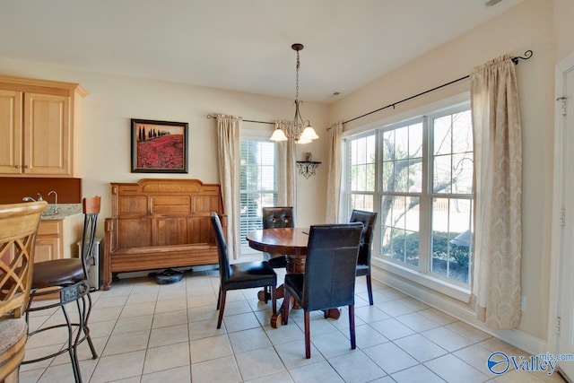 dining room with a chandelier and light tile patterned flooring