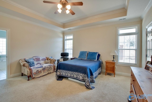 bedroom with visible vents, light colored carpet, a raised ceiling, and multiple windows