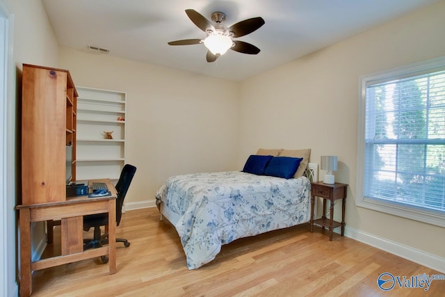 bedroom featuring ceiling fan, visible vents, baseboards, and wood finished floors