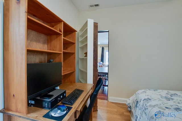 bedroom featuring light wood finished floors, visible vents, and baseboards