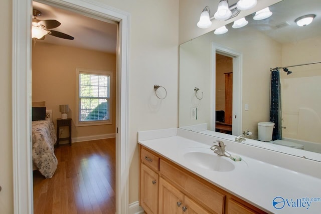 ensuite bathroom with visible vents, a ceiling fan, wood finished floors, connected bathroom, and vanity