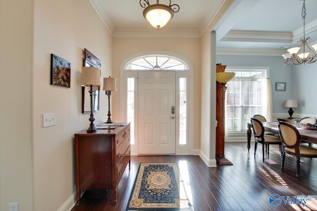 entryway with crown molding, a notable chandelier, and dark wood-style flooring