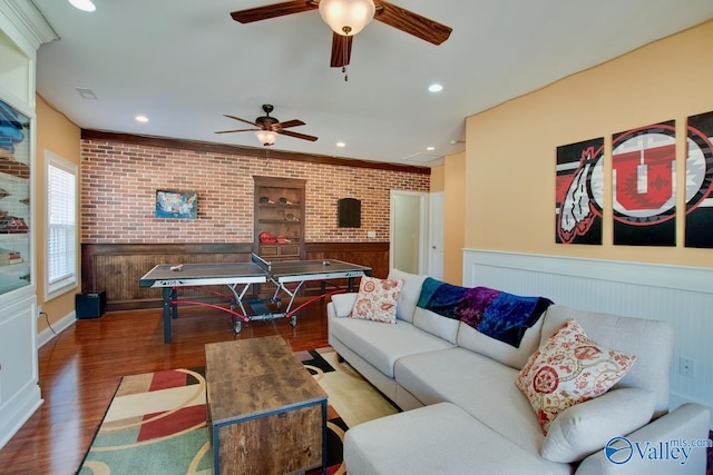 rec room featuring recessed lighting, wood finished floors, brick wall, and wainscoting