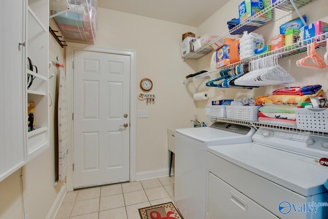 laundry room with washer and dryer, laundry area, light tile patterned floors, and baseboards