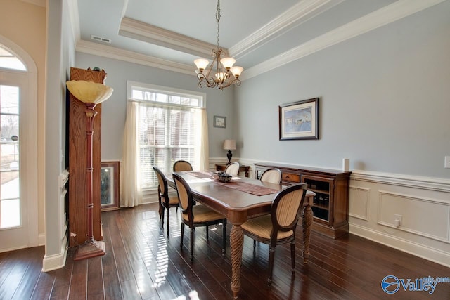 dining space with a raised ceiling, plenty of natural light, visible vents, and dark wood-style flooring