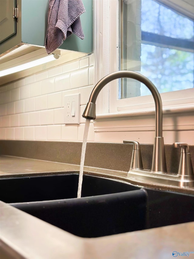 interior details featuring a sink and backsplash