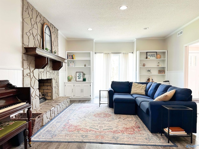 living room featuring ornamental molding, a textured ceiling, and visible vents
