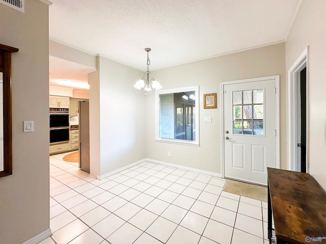 foyer entrance featuring an inviting chandelier, light tile patterned flooring, a textured ceiling, and visible vents