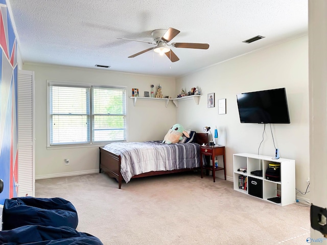 bedroom featuring visible vents, ceiling fan, carpet flooring, and a textured ceiling