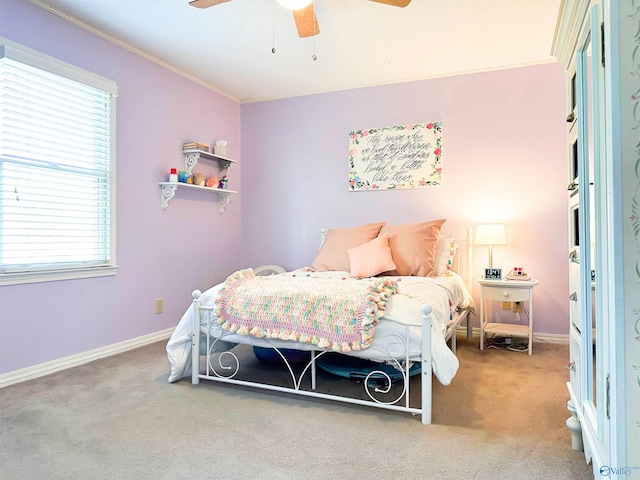 carpeted bedroom featuring baseboards, ornamental molding, and a ceiling fan