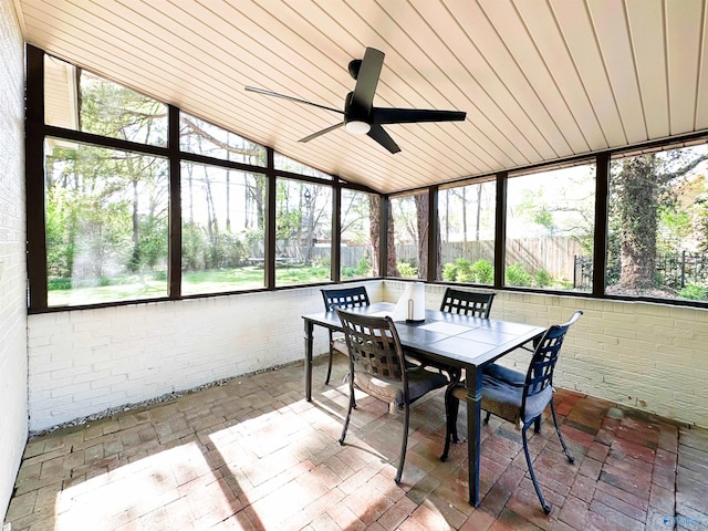 sunroom / solarium with ceiling fan and outdoor dining space