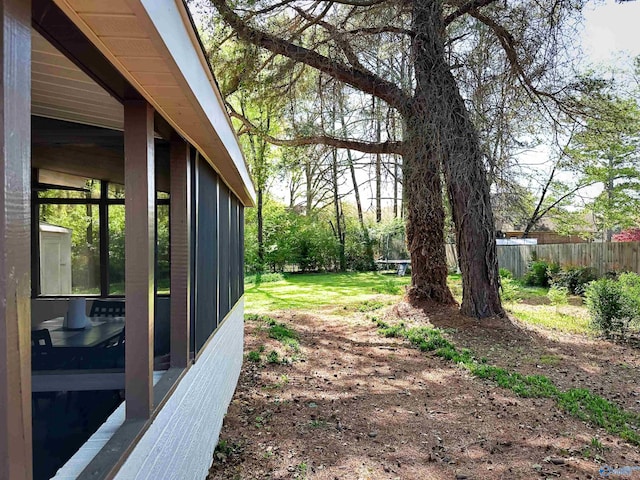 view of yard with a sunroom and fence