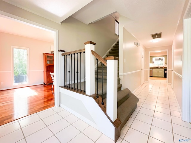 staircase featuring baseboards, visible vents, and tile patterned floors