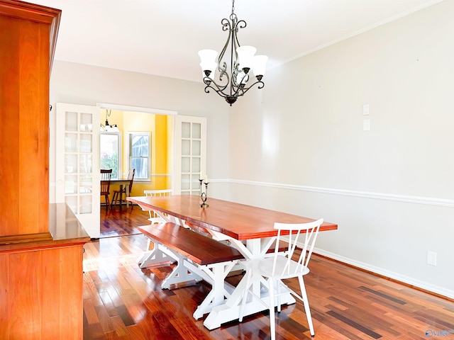 dining area featuring baseboards, a chandelier, and wood finished floors